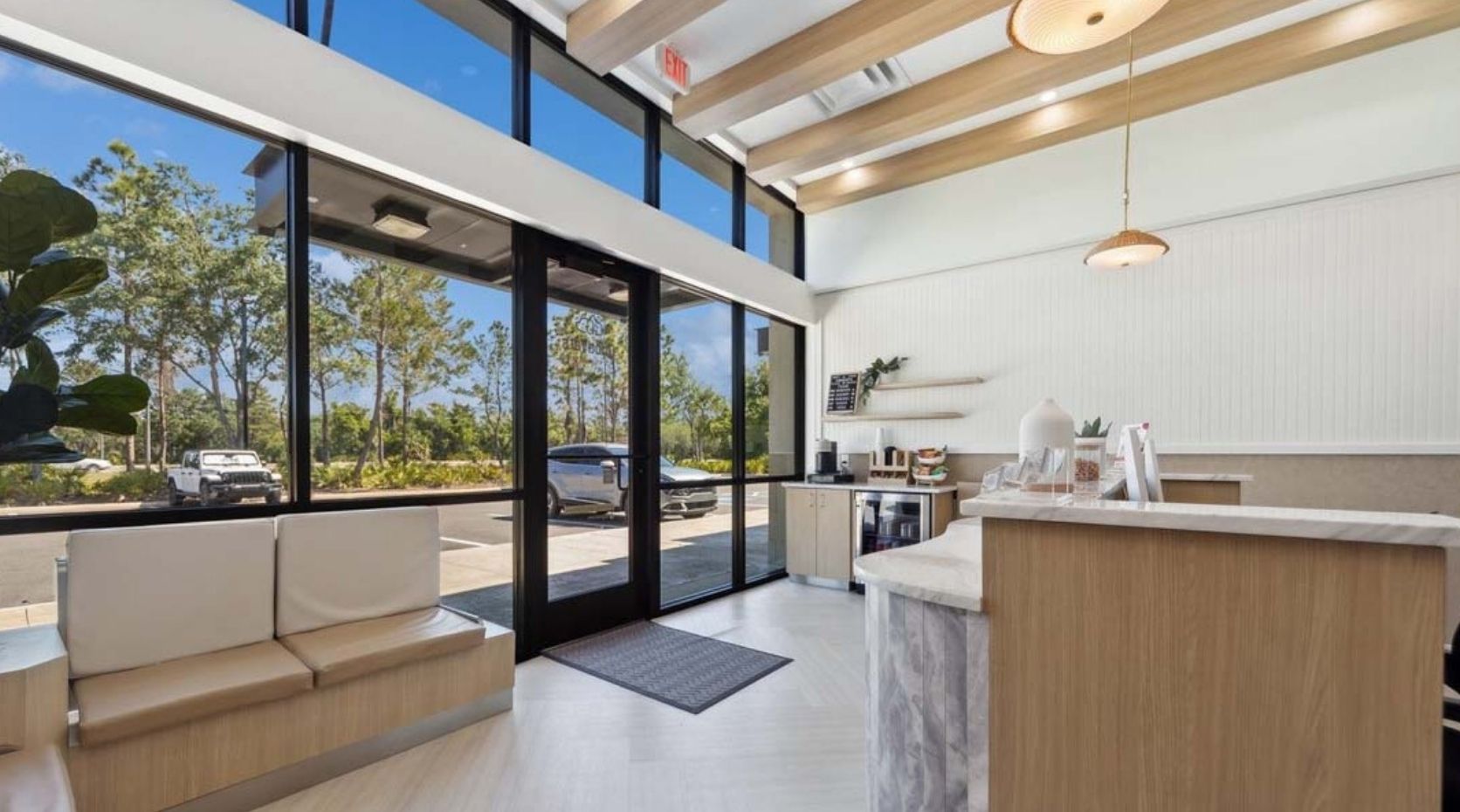 Animal hospital reception area with a wood-paneled desk, floor-to-ceiling windows, and built-in bench seating.